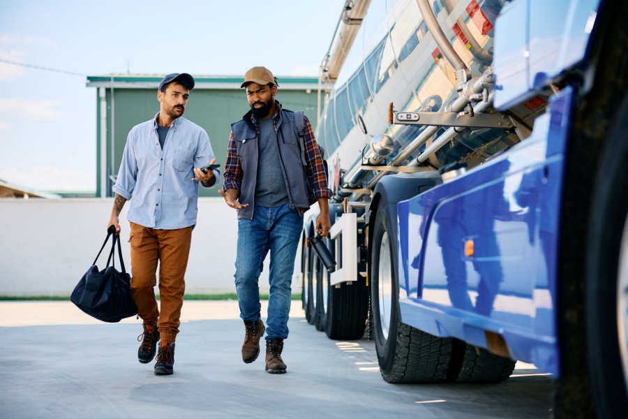 Drivers in the trucking industry walking alongside a rig.