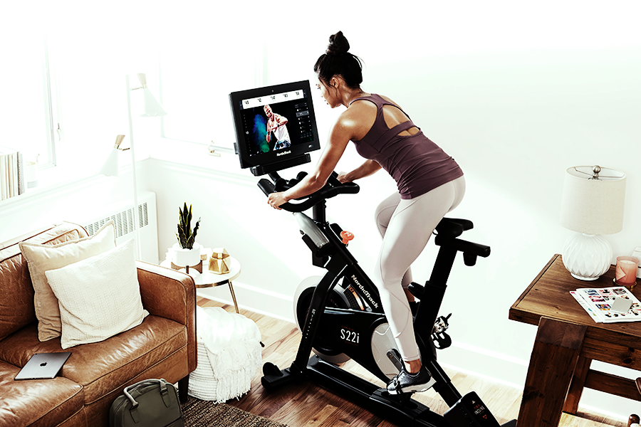 Woman riding on a stationary bike that was built by the white glove delivery team